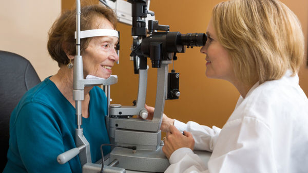 Slechtziende vrouw krijgt oogonderzoek door optometrist Slechtziende vrouw krijgt oogonderzoek door optometrist