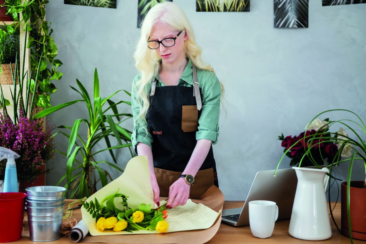 Vrouw met albinisme is aan het bloemschikken