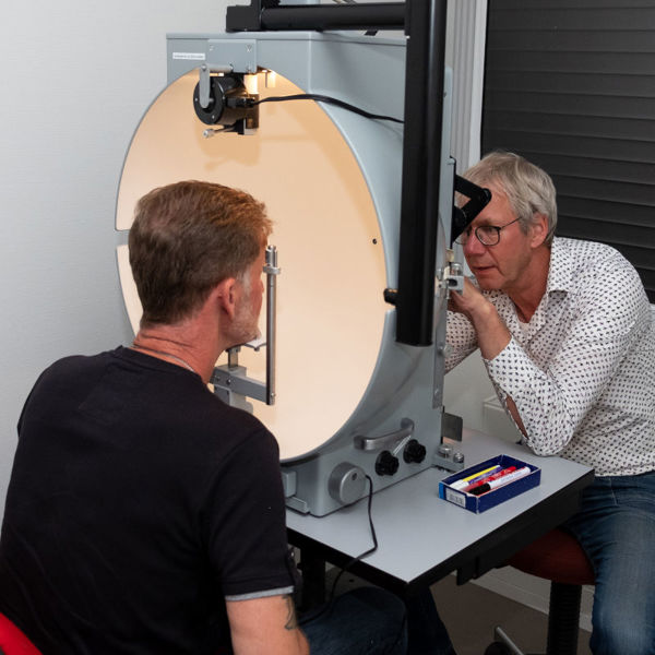 Cliënt en optometrist tijdens het visueel functieonderzoek Cliënt en optometrist tijdens het visueel functieonderzoek
