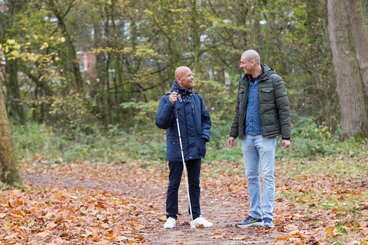 Cliënt loopt samen met ambulant specialistisch begeleider door het bos. 