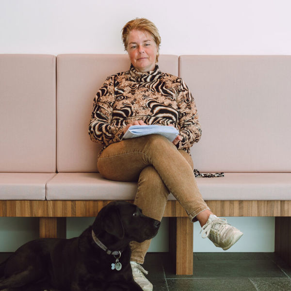 Blinde vrouw zit op bankje met haar geleidehond voor zich Blinde vrouw zit op bankje met haar geleidehond voor zich