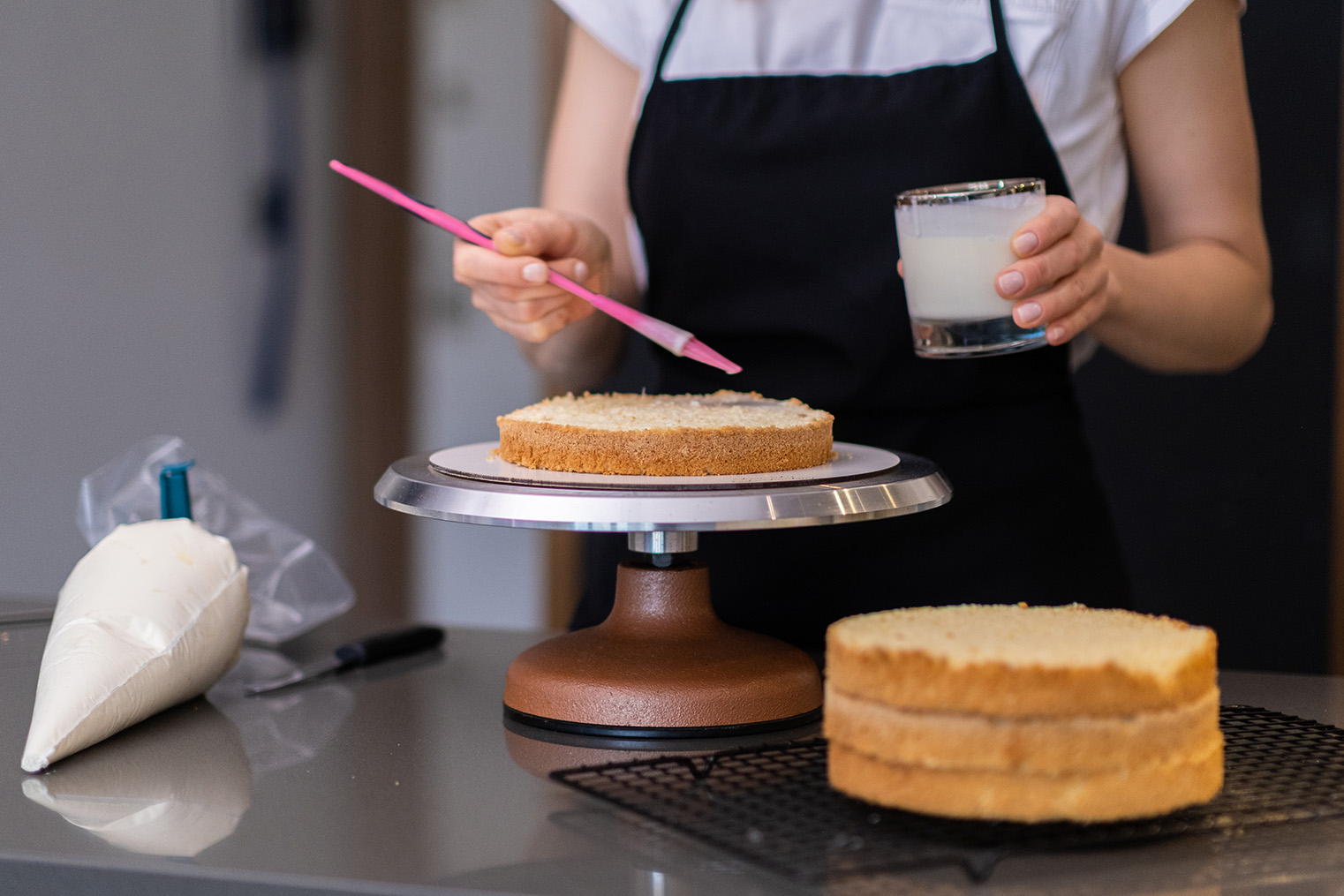 skilled-housewife-using-brush-to-smear-fresh-cake-2024-12-01-18-26-22-utc.jpg