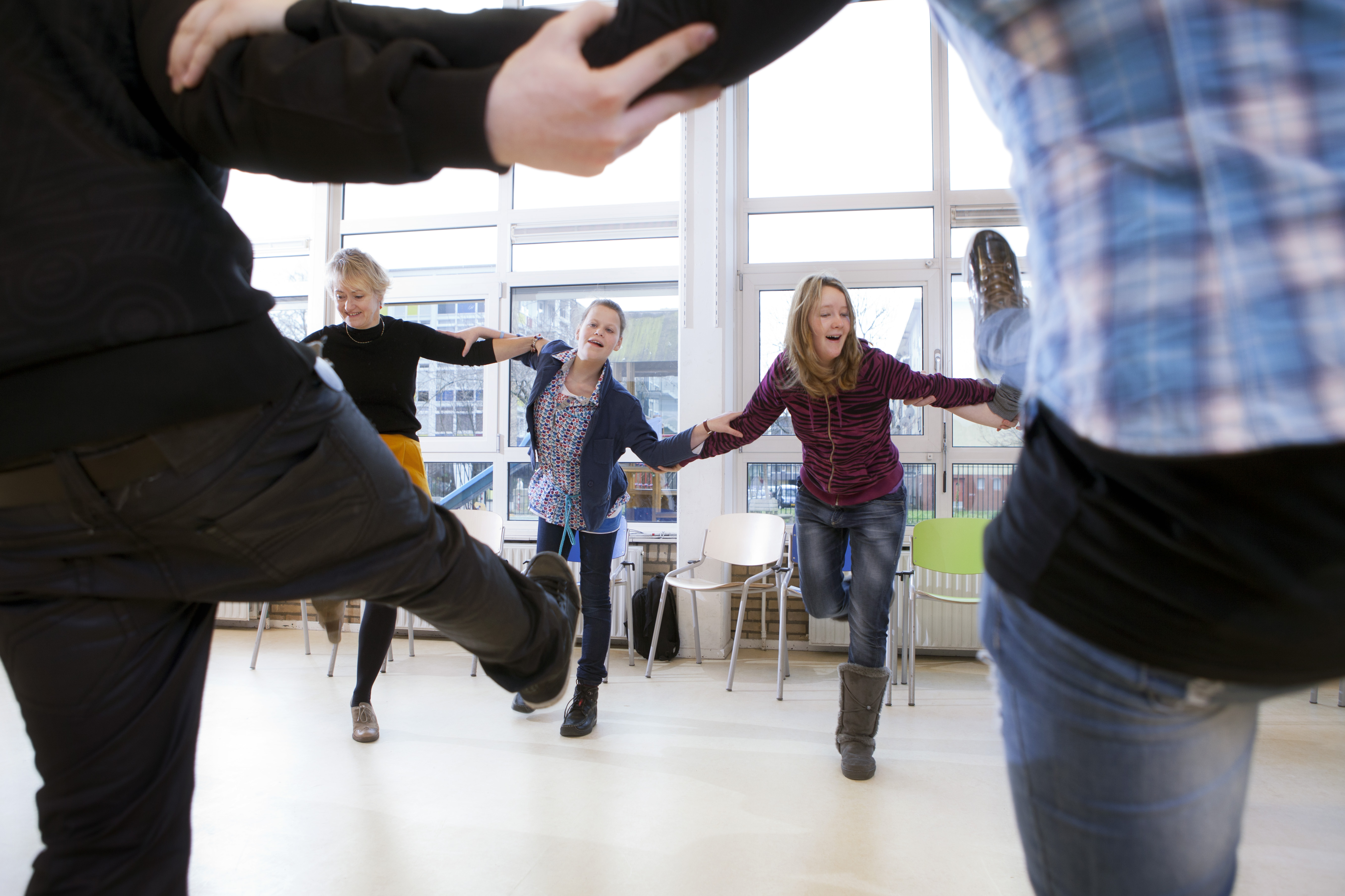 Leerlingen dansen samen in een kring. 