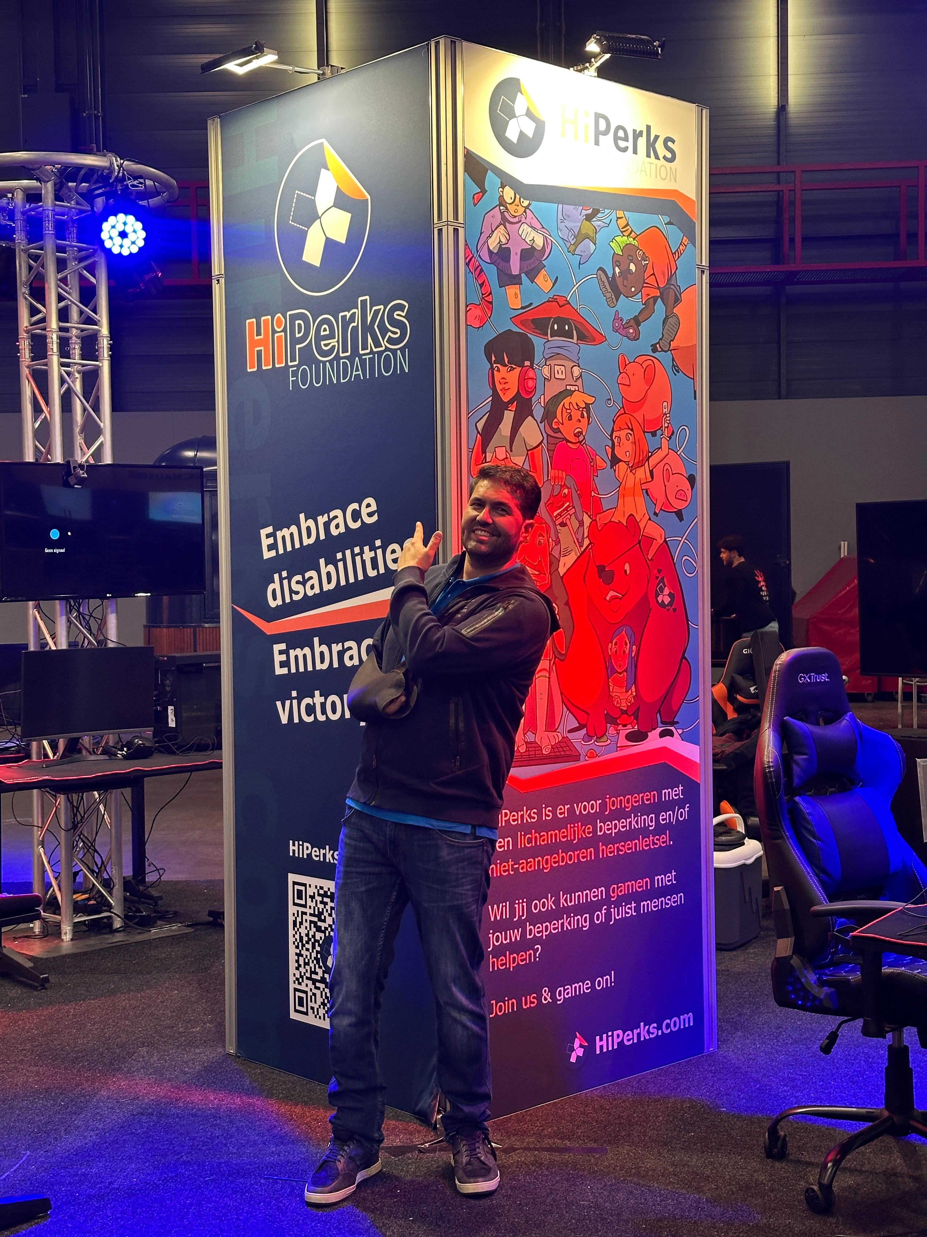 Paul poseert bij bord van zijn stichting Hi Perks 