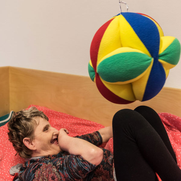 Vrouw speelt liggend in bed met een bal Vrouw speelt liggend in bed met een bal