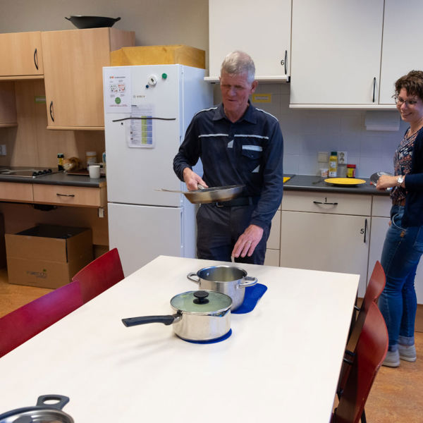 Cliënt oefent in een speciale, toegankelijke keuken van Visio Het Loo Erf met koken Cliënt oefent in een speciale, toegankelijke keuken van Visio Het Loo Erf met koken